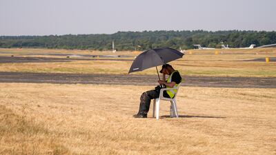 A member of staff shelters from the sun. AP