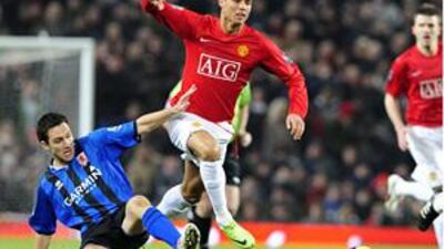 Cristiano Ronaldo, centre, hurdles the challenge of Middlesbrough's Stewart Downing.
