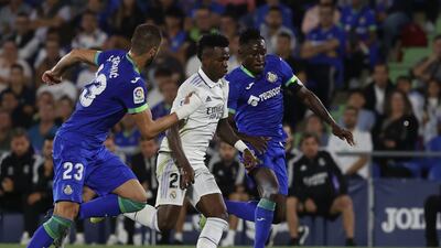 Real Madrid forward Vinicius Jr runs with the ball between Getafe players Djene Dekounam and Domingos Duarte. EPA