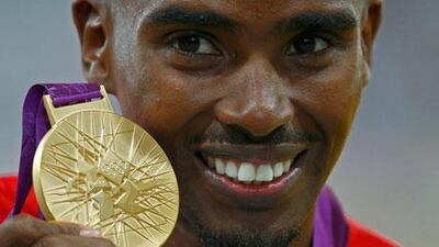 Mo Farah holds up his gold medal for winning the 5,000m at London 2012