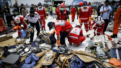 Indonesian rescuers sort recovered debris.