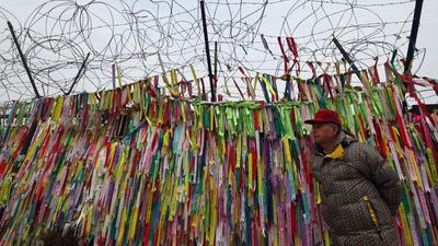 A man walks past a military fence covered with ribbons calling for peace and reunification at the Imjingak peace park near the Demilitarized Zone dividing the two Koreas at the border city of Paju. The two Koreas agreed last week to hold their first official dialogue in more than two years. Jung Yeon-Je / AFP