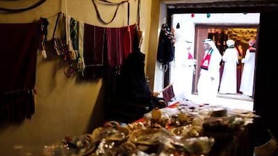 An Emirati vendor awaits customers in her market stall at Souq Al Qattara.