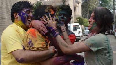 Indian revellers cover each other with colour during the Festival of Colours. Raveendran / AFP Photo