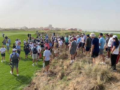 Spectators help Rory McIlroy find his ball after his wayward opening shot at the Abu Dhabi HSBC Championship at Yas Links.