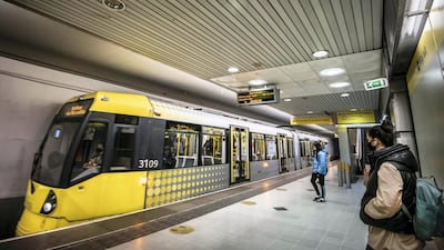 People board a Metrolink tram at Piccadilly station. Darren Robinson for The National