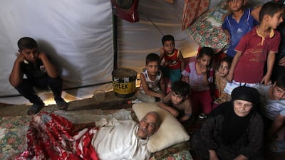 An Iraqi family, who fled the city of Ramadi after it was seized by ISIL, gather inside a tent at a camp housing displaced families in Bzeibez. Ahmad Al Rubaye / AFP Photo