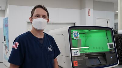 Matthew Tugwell poses next to a machine that extracts mRNA. Willy Lowry / The National