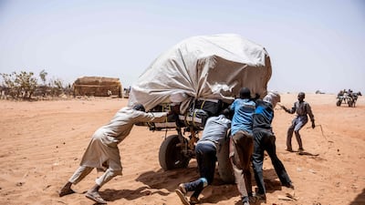 Men push a cart at the Adre border post between Sudan and Chad. AFP