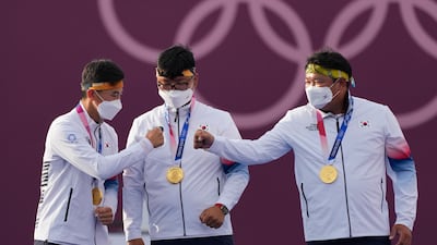 From left, gold medal winners South Korea's Kim Je Deok, Kim Woojin, and Oh Jinhyek celebrate during the men's team medal.