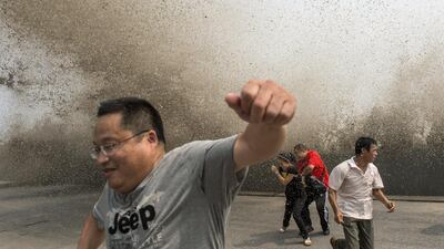 Visitors run away from a wave caused by a tidal bore which surged past a barrier on the banks of Qiantang River, in Hangzhou, Zhejiang province, China. China Daily / Reuters