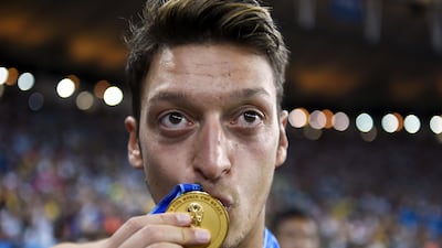Germany's midfielder Mesut Ozil kisses his medal after Germany won the 2014 FIFA World Cup final football match between Germany and Argentina. AFP