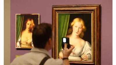 A visitor to the National Gallery in London views altered (left) and restored versions of Woman at a Window (unknown artist, c. 1510-1530), part of the Close Examination: Fakes, Mistakes and Discoveries exhibition.