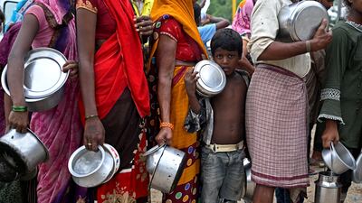 A child queues to receive food at a temporary shelter after flooding in New Delhi. AFP