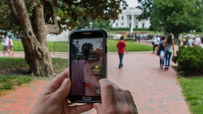 A woman holds up her cell phone as she plays the Pokemon Go game in Lafayette Park in Washington. AFP