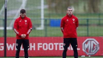 Wales' Gareth Bale and Ben Davies, left, observe a minute's silence as part of remembrance commemorations during training. Reuters