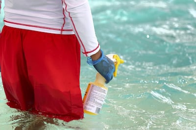 A lifeguard cleans the slides and pools at Wild Wadi in Dubai, which has now reopened, wtih Covid-19 safety measures in place. Chris Whiteoak / The National