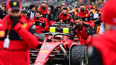 Ferrari's Charles Leclerc sits in his car as he is pushed by his team in the pits. AFP