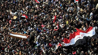 The body of a protester killed during clashes with police is carried through Tahrir Square during his funeral yesterday.