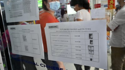 People queue to purchase protective face mask, sanitizer and thermometer at a pharmacy in Singapore. AFP