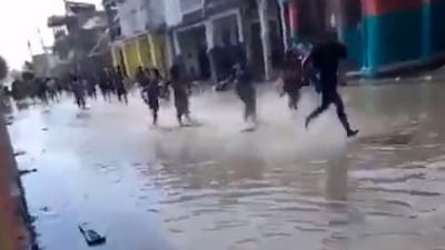 A handout picture made available by Jean David Geneste shows people running in a street after the earthquake.