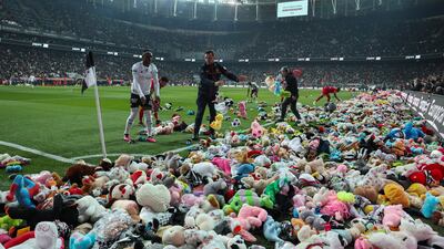 Fans throw toys onto the pitch during the Turkish Super League soccer match between Besiktas and Antalyaspor at the Vodafone stadium in Istanbul, Turkey, Sunday, Feb. 26, 2023. During the match, supporters threw a massive number of soft toys to be donated to children affected by the powerful earthquake on Feb. 6 on southeast Turkey. (AP Photo)