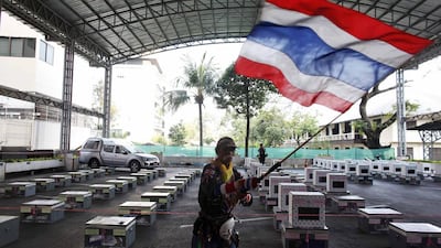 An anti-government protester waves inside a district office next to election boxes which are to be delivered to polling stations, just before the beginning of voting in Bangkok. Nir Elias