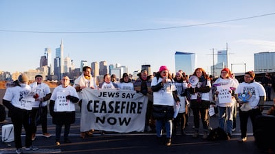 Protesters from the national group Jewish Voice for Peace call for a ceasefire in the Israel-Hamas war during rallies across the US marking the 8th night of Hanukkah as they block a highway in Philadelphia, Pennsylvania, on December 14. Reuters