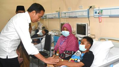 Indonesia’s President Joko Widodo visiting a survivor at a hospital in Malang, East Java, after a stampede that killed at least 131 people in one of the deadliest disasters in football history. AFP