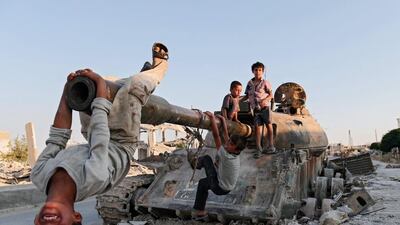 Syrian children play on a destroyed tank south of Kobane, Syria. Sedat Suna / EPA