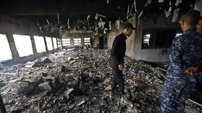 Libyan police check the damage at the Libyan electoral commission headquarters in the capital Tripoli after it was targeted by suicide bombers on May 2, 2018. Suicide bombers stormed Libya's electoral commission in the Libyan capital, killing at least 14 people in an attack claimed by ISIS. Mahmud Turkia / AFP