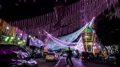 Vehicles drive past a stall selling Ramadan lanterns along a main street in Shubra, Cairo. The government is increasing electricity-saving measures amid soaring global oil prices. AFP