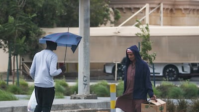 Pedestrians walk in strong winds in Khalifa City. Victor Besa / The National