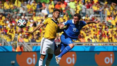 Teofilo Gutierrez of Colombia jumps with Vasilis Torosidis of Greece during their Group C match at the 2014 World Cup on Saturday. Paul Gilham / Getty Images