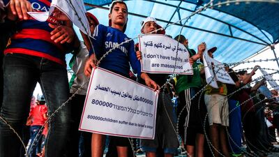 Palestinian children demonstrate with signs at the Erez crossing with Israel near Beit Hanun in the northern Gaza Strip on July 24, 2018 against Israel's blockade on the enclave. AFP
