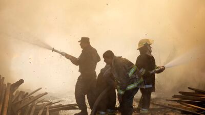 Afghan firefighters try to extinguish a fire which broke out at a wood market in Kabul, Afghanistan. Omar Sobhani / Reuters