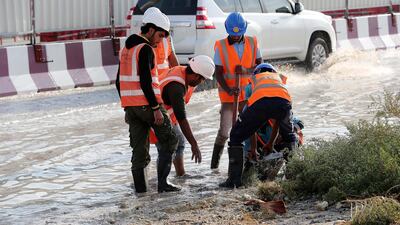 Workers at the under construction Dubai Metro site clear the blocked drainage because of rain in the Discovery Gardens area. Pawan Singh / The National