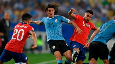 Uruguay's Edinson Cavani is marked by Chile's Charles Aranguiz and Paulo Diaz. AFP