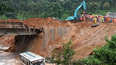 A bus lies partially submerged in a flooded river following landslides triggered by heavy rains in Wayanad. AFP