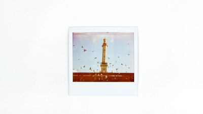 Interrupted from their lunch of bread, pigeons fly up toward a minaret at the Dubai Creek's souk area.