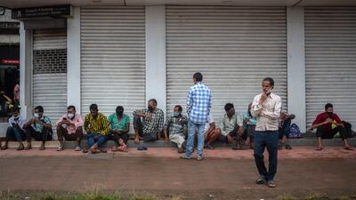 Daily wage labourers wearing face masks wait to be hired for the day in the morning in Kochi, Kerala state, India. AP