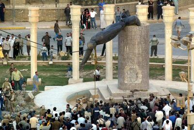Iraqis watch a statue of President Saddam Hussein falling in Baghdad's Al Fardous (paradise) square on April 9, 2003. Patrick Baz / AFP Photo
