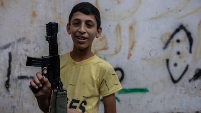 Karam, 14, with a toy gun in Nur Shams refugee camps. Karam grew up a refugee - he has never been able to leave Nur Shams camp