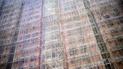 Bamboo scaffolding and meshing is seen over a residential complex in Hong Kong on September 6, 2014. Housing prices in the southern Chinese city have roughly doubled since 2009, with prices being pushed up by buyers from mainland China. Alex Ogle / AFP