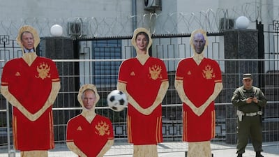 A ball flies towards cut-out portraits of Russian leaders during a rally demanding to deprive Russia of the right to host 2018 World Cup in Kiev, Ukraine. Valentyn Ogirenko / Reuters
