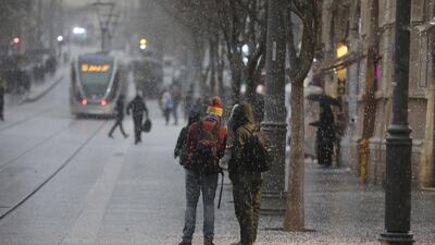 People watch hail fall in the centre of Jerusalem. EPA