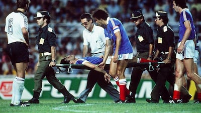 French defender Patrick Battiston evacuated on a stretcher eyed by French forward Michel Platini after colliding with German goalkeeper Harald Schumacher during the World Cup semi-final match France vs Germany. (AFP PHOTO)