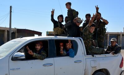 Fighters from Syrian Democratic Forces flash the victory sign as they drive at the northern entrance of Raqqa, Syria, on October 18, 2017. Youssef Rabih Youssef / EPA