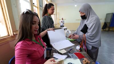 Algerian electoral officials check the identification of a voter at a polling station on election day in Algiers. About 24 million Algerians are expected to take part. AFP