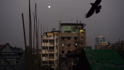 A crow flies over rows of residential apartments at dawn over Yangon. Romeo Gacad / AFP Photo